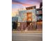 Striking modern home featuring a brick facade, multi-level balconies, and expansive windows with a beautiful sunset backdrop at 1878 W 32Nd Ave, Denver, CO 80211