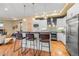 Open kitchen featuring a large island with barstool seating, stainless steel appliances, and modern pendant lighting at 1878 W 32Nd Ave, Denver, CO 80211