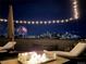 Relaxing rooftop featuring a fire pit and city views under a string of festive lights and fireworks at 1878 W 32Nd Ave, Denver, CO 80211