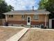 Backyard of the home featuring brick construction and a concrete walkway at 1283 Lipan Dr, Denver, CO 80221