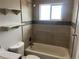 Modern bathroom with updated tile, fixtures, a tub with shower, and floating shelves at 1283 Lipan Dr, Denver, CO 80221