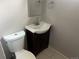Bathroom with white toilet and sink with vanity featuring tile floor at 1283 Lipan Dr, Denver, CO 80221