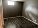 Bedroom with dark wood-look vinyl plank flooring and one window providing natural light at 1283 Lipan Dr, Denver, CO 80221