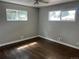 Bright bedroom with hardwood floors, two windows, and a ceiling fan at 1283 Lipan Dr, Denver, CO 80221