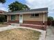 Quaint brick house featuring a classic design with a well-kept lawn and a paved driveway at 1283 Lipan Dr, Denver, CO 80221