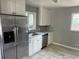 Bright kitchen featuring stainless steel refrigerator and appliances, with white cabinets at 1283 Lipan Dr, Denver, CO 80221