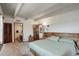 Well-lit primary bedroom with a full bath, large bed with headboard storage, and spacious closet with wooden doors at 3675 S Cherokee St # 710, Englewood, CO 80110