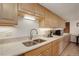 Neutral kitchen features light oak cabinets, quartz countertops, and wood floors at 3675 S Cherokee St # 710, Englewood, CO 80110