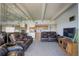 Spacious living room with beamed ceilings, mirrored wall, and open to kitchen with a partial view at 3675 S Cherokee St # 710, Englewood, CO 80110