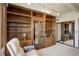 Cozy office space with hardwood floors, a white recliner, generous custom wooden shelving, and decorative display lighting at 3675 S Cherokee St # 710, Englewood, CO 80110