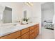 Bathroom with double sinks, a large mirror, and views into the bright bedroom at 534 Stonemont Dr, Castle Pines, CO 80108