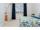 Bright bedroom featuring a window with blue curtains, a colorful bedspread, and an ensuite bathroom at 534 Stonemont Dr, Castle Pines, CO 80108
