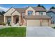 Charming two-story home with a three-car garage, brick accents, and a well-maintained front lawn at 534 Stonemont Dr, Castle Pines, CO 80108