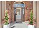 Elegant brick entryway with a large arched window above the front door, framed by decorative planters at 534 Stonemont Dr, Castle Pines, CO 80108
