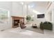 Sunlit living room boasting a brick fireplace, vaulted ceilings, and stylish modern furniture at 534 Stonemont Dr, Castle Pines, CO 80108