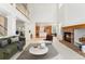 Open-concept living room showcasing a brick fireplace, vaulted ceilings, and seamless access to the kitchen at 534 Stonemont Dr, Castle Pines, CO 80108