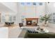 Spacious living room with tall ceilings, brick fireplace, and large windows offering plenty of natural light at 534 Stonemont Dr, Castle Pines, CO 80108