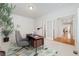 Bright office space with a modern desk, comfortable chair, and French doors leading to the dining room at 534 Stonemont Dr, Castle Pines, CO 80108