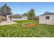 A large backyard with grass, garden box, patio, shed, and back of the house at 5090 Tejon St, Denver, CO 80221