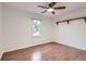 Bright bedroom with wood floors, a shelf, and a window overlooking the yard at 5090 Tejon St, Denver, CO 80221