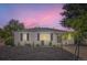 Inviting single-story home with fresh landscaping and a cozy front porch at dusk at 5090 Tejon St, Denver, CO 80221