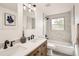 Stylish bathroom featuring marble tiling, dual sinks, wood-style vanity, and a modern bathtub/shower combination at 5203 Scranton St, Denver, CO 80239