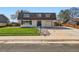Charming two-story home with a well-manicured lawn, blue door and shutters, and an attached garage at 5203 Scranton St, Denver, CO 80239