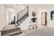 Hallway with stairs, wood floors, neutral carpet, white walls, and modern black handrail at 5203 Scranton St, Denver, CO 80239