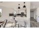 Modern kitchen with white cabinets, dark backsplash, stainless steel appliances, and convenient bar seating at 5203 Scranton St, Denver, CO 80239
