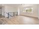Open living area with light hardwood floors, a modern railing, and lots of natural light at 5203 Scranton St, Denver, CO 80239