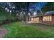 Lush green backyard with mature trees, patio, and an outdoor dining set for entertaining at 5795 Oak Creek Ln, Greenwood Village, CO 80121
