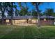 Expansive backyard featuring mature trees, a patio, and an outdoor dining set for entertaining at 5795 Oak Creek Ln, Greenwood Village, CO 80121