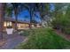 Expansive backyard featuring a lush lawn, mature trees, and a charming patio area with dining set at 5795 Oak Creek Ln, Greenwood Village, CO 80121
