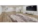 Large basement area featuring a modern entertainment center, stylish flooring, and plenty of open space at 5795 Oak Creek Ln, Greenwood Village, CO 80121