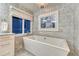 Relaxing bathroom featuring a standalone tub, a large window, and stylish tile work for a spa-like feel at 5795 Oak Creek Ln, Greenwood Village, CO 80121