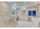 Luxurious bathroom with a glass-enclosed shower, dual sinks, a soaking tub, and elegant marble tiling at 5795 Oak Creek Ln, Greenwood Village, CO 80121