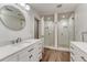 Modern bathroom featuring double shower, wood floor, and double sink with stylish vanity at 5795 Oak Creek Ln, Greenwood Village, CO 80121