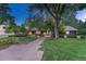 Charming brick home with manicured lawn, mature trees, and inviting walkway at 5795 Oak Creek Ln, Greenwood Village, CO 80121