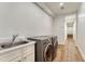 Functional laundry room with modern washer and dryer, sink and bright lighting at 5795 Oak Creek Ln, Greenwood Village, CO 80121