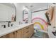 The modern bathroom has a double vanity, playful shower curtain, and sleek finishes at 2540 Jay St, Edgewater, CO 80214