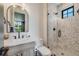 Stylish bathroom with a modern vanity, arch mirror, and tiled shower featuring a glass door at 2540 Jay St, Edgewater, CO 80214