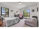 Bright bedroom features a desk, chair, and large windows providing plenty of natural light at 2540 Jay St, Edgewater, CO 80214