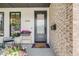 Close-up of a modern home's front door with decorative plants, exterior brick, and black door trim at 2540 Jay St, Edgewater, CO 80214
