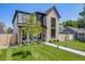 Attractive two-story home with a modern design, green lawn, walkway, mature tree, and fenced yard at 2540 Jay St, Edgewater, CO 80214