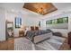 This bedroom features a wood tray ceiling, chandelier, large windows, and sleek black window trim at 2540 Jay St, Edgewater, CO 80214