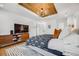 The beautiful bedroom has white walls, wood floors, wood ceiling inlay, recessed lights, and a chandelier at 2540 Jay St, Edgewater, CO 80214