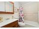 Cozy bathroom featuring a vanity, toilet, and bathtub with a shower and colorful curtain at 12223 W 60Th Pl, Arvada, CO 80004