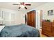 Bedroom with dark blue comforter, ceiling fan, wood floors and connecting bathroom at 12223 W 60Th Pl, Arvada, CO 80004