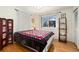 Bedroom with hardwood floors, natural light, and a decorative quilt on the bed at 12223 W 60Th Pl, Arvada, CO 80004