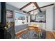 Cozy dining area with wood beams, wood stove, and bright window overlooking the outdoors at 12223 W 60Th Pl, Arvada, CO 80004